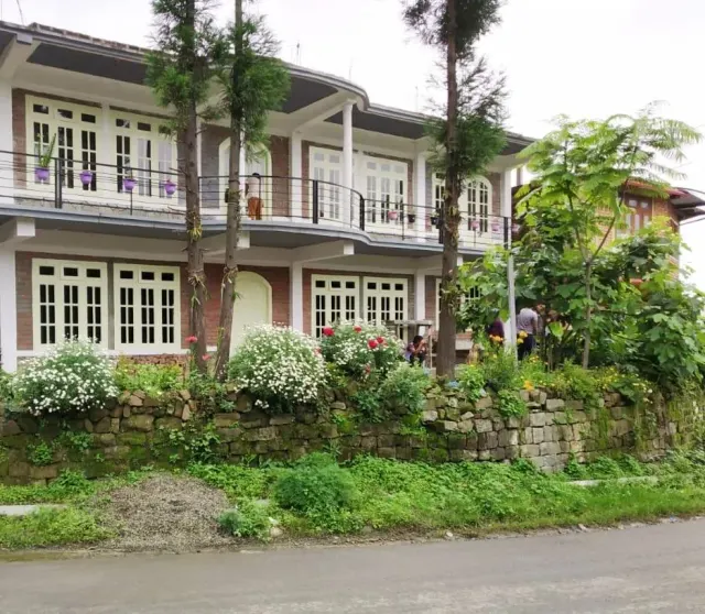 The two-storey homestay building near Kisama with a garden in front